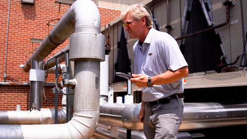 maintenance worker running diagnotics on a chiller with iPad